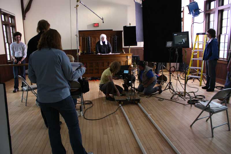 The camera crew tests the dolly placement while actors Kevin Cunningham and Macleish Day are in place